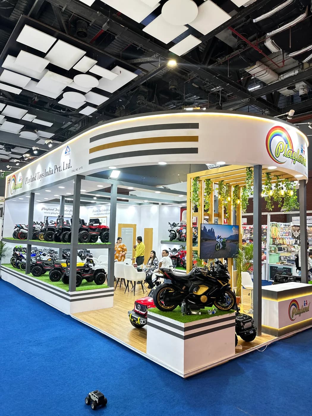 Playland expo corner with premium ride-on bike display and illuminated booth signage