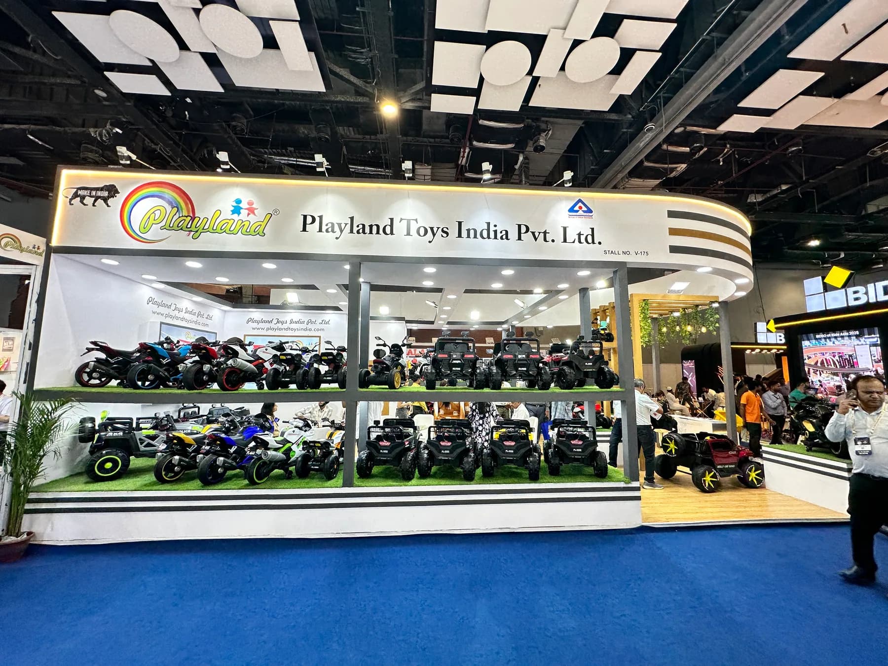 Playland Toys India expo booth with ride-on jeeps and bikes on display