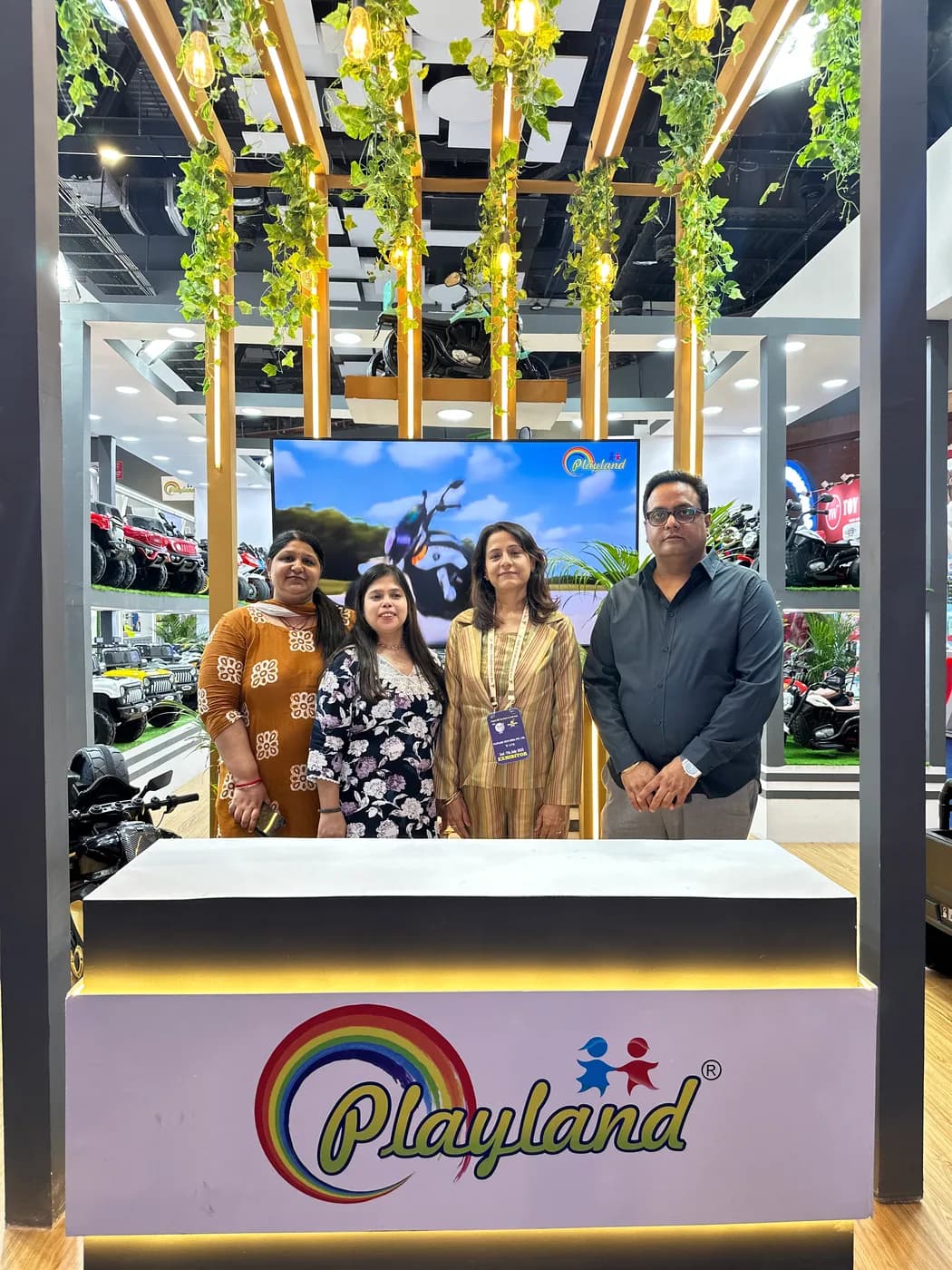 Playland team at the expo counter in front of the brand display